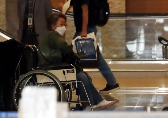한국배우 최초로 아카데미 여우조연상을 수상한 배우 윤여정이 미국 일정을 마치고 8일 인천국제공항 제2터미널을 통해 귀국, 휠체어에 앉아 있다. 그는 이후 걸어서 공항을 빠져나갔다. 사진=뉴시스
