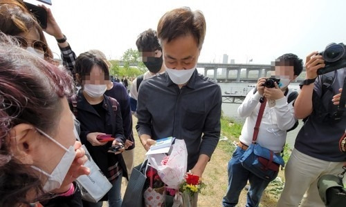 어버이날이었던 지난 8일 오후 서울 반포 한강공원 수상택시 승강장 인근에서 시민들이 고(故) 손정민 씨의 아버지 손현씨에게 카네이션 등 선물을 전달하고 있다. 연합뉴스