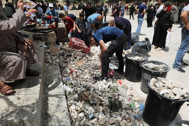10일(현지시간) 팔레스타인 주민들이 예루살렘 올드시티 알 아크사 모스크에서 이스라엘 경찰과 충돌을 대비해 양동이에 돌을 채우고 있다. 로이터