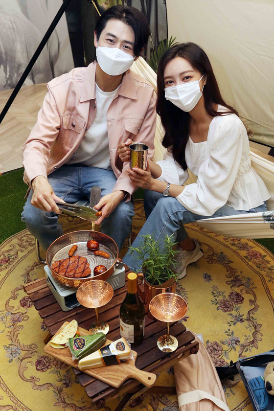 Models pose with camping equipment to promote Shinsegae Department Store's Terrace Home Camping event at the department store's main branch in Myeong-dong, central Seoul, on Thursday. The event runs from Thursday until May 31, offering a variety of camping equipment from brands such as Basil Bangs, Lumiere 9 and Hatton Heritage. [YONHAP]