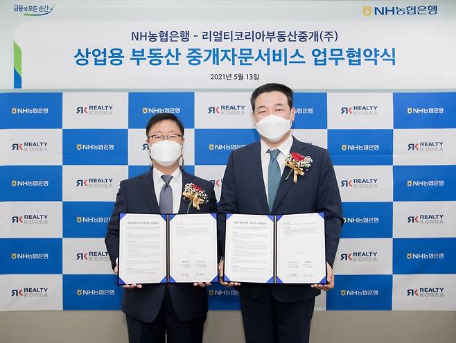 남재원 NH농협은행 부행장(왼쪽)과 유진석 리얼티코리아부동산중개 대표이사가 지난 13일 개최된 업무협약식에서 기념촬영을 하고 있다./사진=NH농협은행