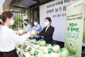 김윤혜 호반프라퍼티 부사장(가운데)이 임직원에게 양배추를 나누고 있다.