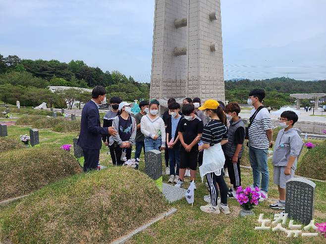 전주 동북초등학교 학생들이 14일 광주 북구 운정동 국립5·18민주묘지에서 해설사의 설명을 듣고 있다. 김한영 기자