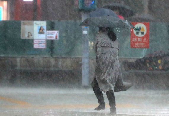 서울 광화문네거리에서 시민이 갑자기 내린 폭우에 발걸음을 옮기고 있다.뉴스1
