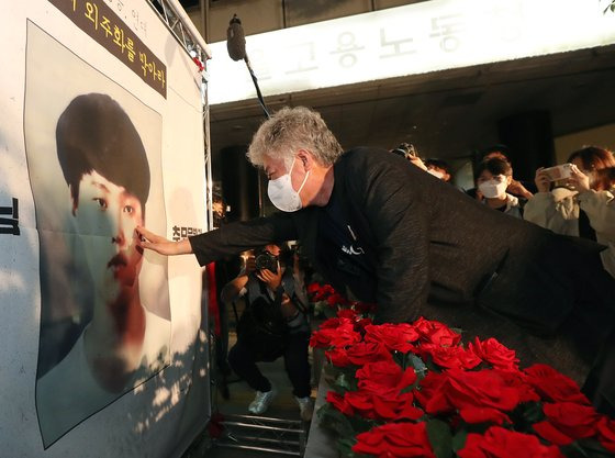 고 이선호군 아버지 이재훈씨가 지난 13일 중구 서울지방고용노동청 앞에서 열린 고 이선호군 추모문화제에서 이군 사진 앞에 놓인 컨테이너모형에 장미꽃을 놓은 후 사진을 어루만지고 있다. 뉴스1