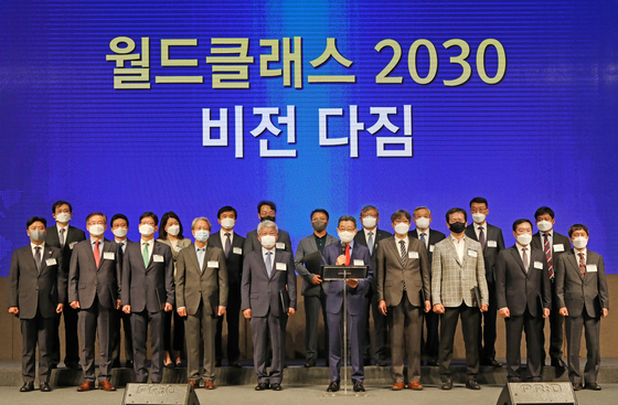 Oh Suk-song, chairman of Korea World Class Enterprise Organization, center, and representatives from 19 companies that have been selected for the second World Class project, pose for a photo during a vision declaration ceremony held at the Seoul Dragon City hotel in Yongsan District, central Seoul, on Friday. [PARK SANG-MOON]
