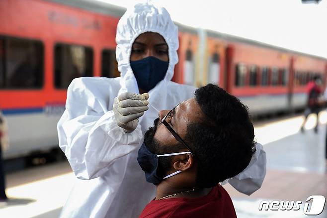 인도 뭄바이에서 2021년 5월 13일 한 장거리 열차 승객이 코로나19 검진을 받는 모습.  © AFP=뉴스1
