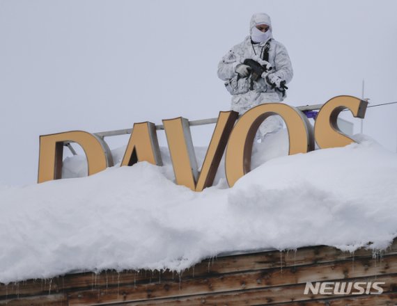 지난 2019년 스위스의 무장경찰 1명이 연례 세계경제포럼(WEF, 일명 다보스 포럼)이 열리는 다보스의 한 호텔 지붕 위에서 경계를 서고 있다. AP뉴시스