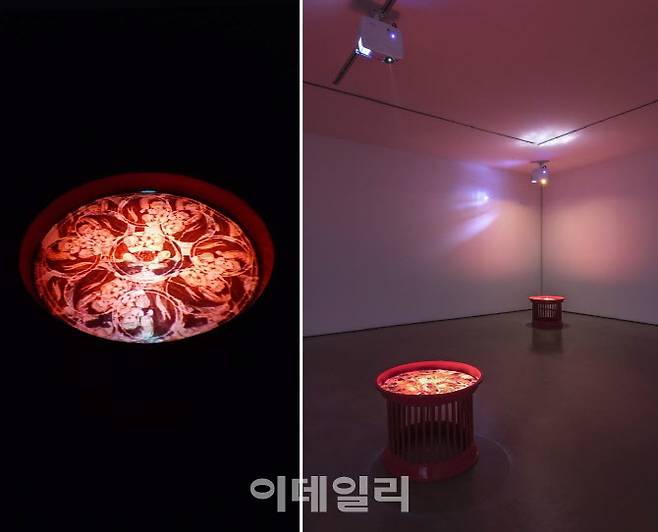 박현기의 ‘만다라 연작’(1997∼1998) 중 한 점(왼쪽)과 전시 전경. 비디오작업의 결정판이라 할 말년의 역작이다. 붉은 옷칠을 한 의례용 헌화대 위에 투여한 영상은 기하학적 불교도상과 포르노그래피 등이 어지럽게 겹쳐지며 무한히 반복재생된다(사진=오현주 문화전문기자·갤러리현대).
