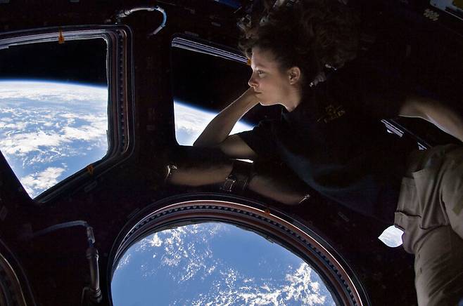 국제우주정거장의 전망창 큐폴라에서 한 우주비행사가 지구를 내려다보고 있다. 스페이스 어드벤처스 제공