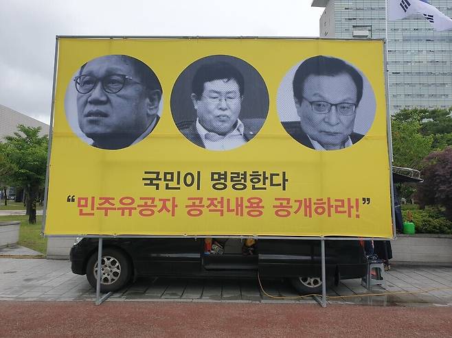 Turn Right, a conservative group, holds a protest Monday demanding the South Korean government disclose a list of persons of merit from the May 18 Democratization Movement [in 1980], with a banner containing images of current and former lawmakers with the Democratic Party. (Kim Yong-hee/The Hankyoreh)