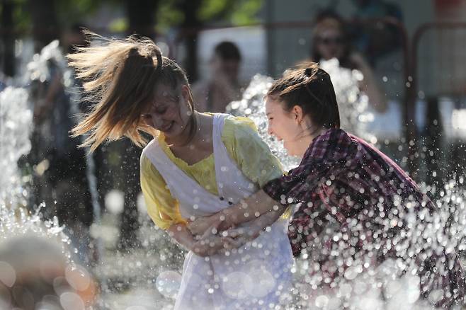 이상고온 현상이 나타난 러시아 모스크바에서 17일(현지시간) 시민들이 분수대에서 물놀이를 즐기며 더위를 식히고 있다. |타스연합통신