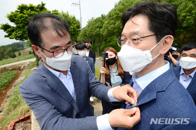 [남해=뉴시스]차용현 기자 = 경남 남해군 장충남 군수가 18일 오후 남해군 서면과 전남 여수시를 연결하는 해저터널 예정지를 방문한 김경수 경남지사에게 해저터널 건설을 기원하는 배지를 달아주고 있다. 2021.05.18.con@newsis.com