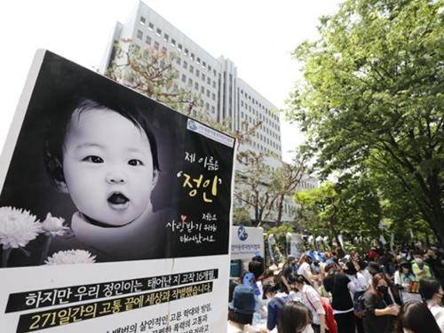 '정인이' 양부모의 1심 선고 공판이 열린 14일 서울 양천구 서울남부지방법원 입구에서 시민들이 강력한 처벌을 촉구하는 피켓을 들고 있다. 뉴시스