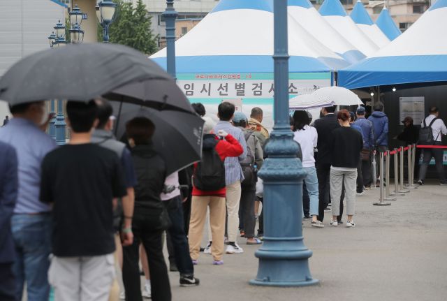 20일 오전 서울역광장에 마련된 임시선별진료소에서 시민들이 코로나19 검사를 받기 위해 줄을 서 있다. 연합뉴스