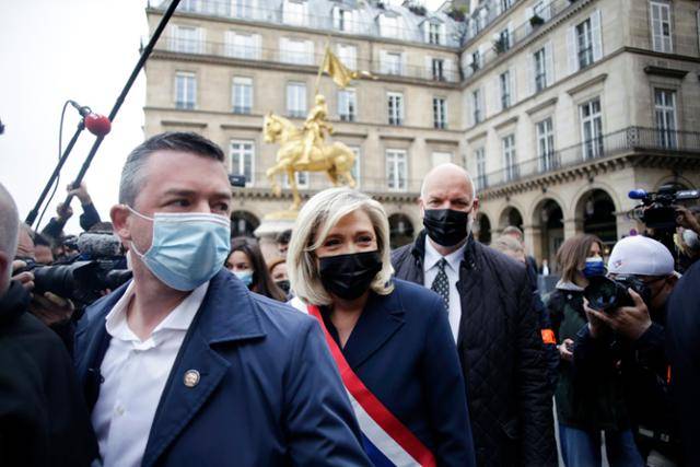 1일 잔 다르크 동상이 있는 프랑스 파리의 피라미드 광장에서 열린 노동절 행사에서 극우 정당 국민연합의 마리 르펜(가운데) 대표가 행사장을 떠나고 있다. 파리=AP 연합뉴스