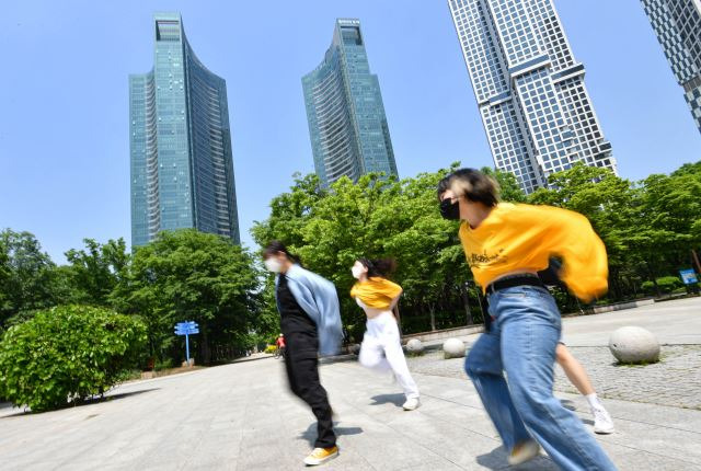 청년들이 지난 18일 서울 성동구 성수동 갤러리아포레 아파트 인근 서울숲 공원에서 춤을 추고 있다. 갤러리아포레는 최근 매매 가격이 35억~40억원인 주상복합 아파트다. 이한결 기자