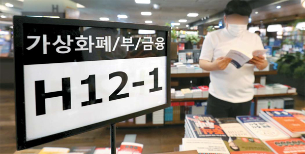 최근 MZ세대가 빚까지 져가며 공격적인 투자에 나선다는 우려가 나오는 가운데 서울 시내 대형 서점에서 한 대학생이 가상화폐 투자 관련 서적을 읽고 있다. [이충우 기자]