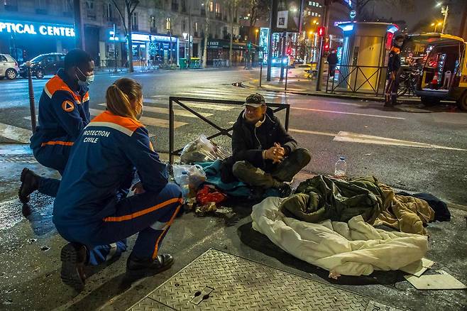 3월10일 프랑스 시민단체 자원봉사자들이 파리의 노숙자와 이야기를 나누고 있다. ⓒEPA