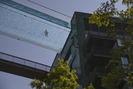 건물과 건물 사이에 지어진 구름다리 투명 수영장 35미터 높이다. [AP=연합뉴스]