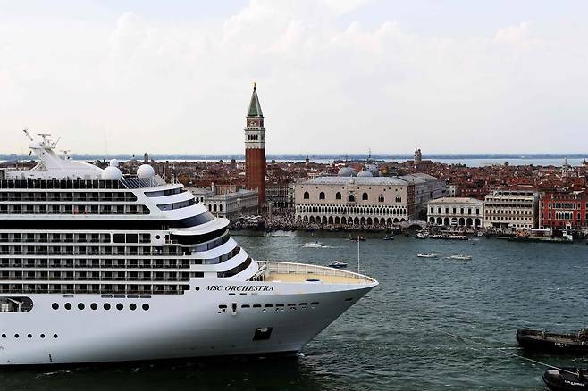 대형 크루즈선 MSC 오케스트라가 5일 예인선에 이끌려 베네치아 역사지구 운하를 통과하고 있다. 뒤로 베네치아 종탑과 원수궁전이 보인다. AFP=연합뉴스