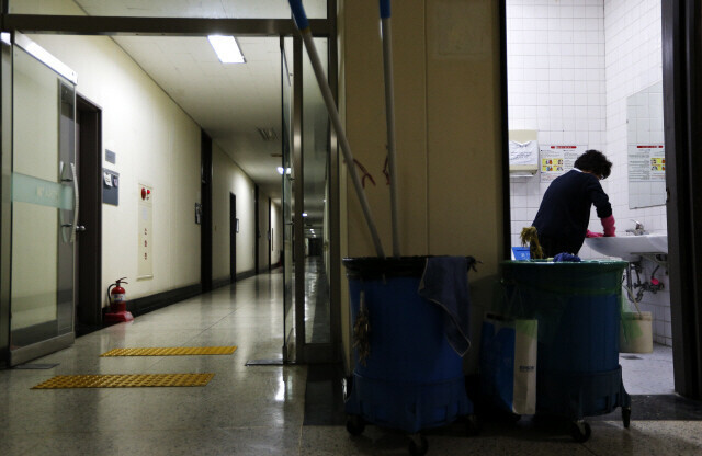 한 대학의 청소노동자가 이른 아침 출근해 화장실 세면대를 닦고 있다. <한겨레> 자료사진