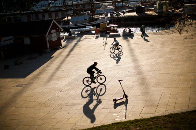 4월 26일 노르웨이 오슬로의 마리나 항구에서 시민들이 자전거를 타고 있다. 오슬로=AP 뉴시스