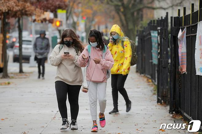 미국 뉴욕시 브루클린에서 행인들이 마스크를 착용하며 길을 걷고 있다. © 로이터=뉴스1 © News1 정윤영 기자
