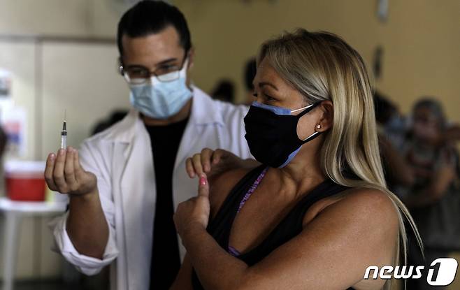 브라질 리우데자네이루에서 코로나19 백신 접종을 하고 있는 한 여성. © 로이터=뉴스1