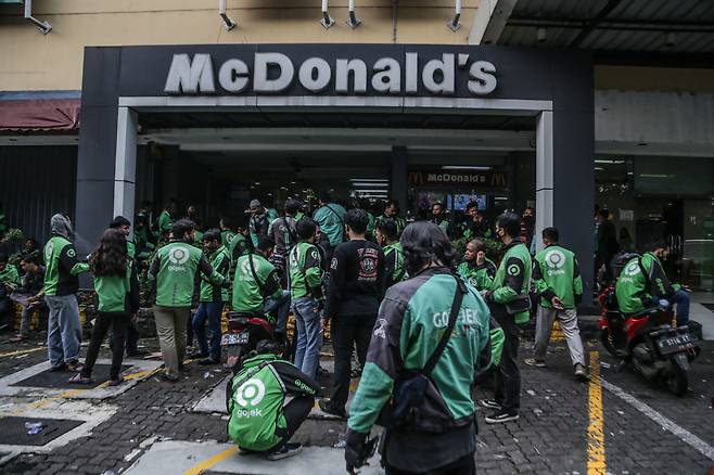 자카르타 남부 외곽 도시 보고르의 한 맥도날드 매장에 배달기사 수십여명이 BTS 세트를 사기 위해 몰린 모습. 매장 안을 꽉 채운 배달기사들이 매장 바깥에까지 줄을 서 있다. /AFP 연합뉴스