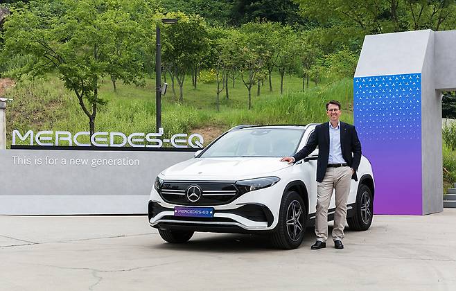 Mercedes-Benz Korea CEO Thomas Klein poses with the Mercedes-Benz EQA at Oil Tank Culture Park in Seoul on Thursday. (Mercedes-Benz Korea)