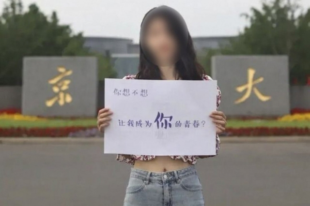 여학생이 "내가 네 청춘의 일부가 되길 바라니"라고 적힌 팻말을 들고 있는 난징대 광고. /웨이보 캡처