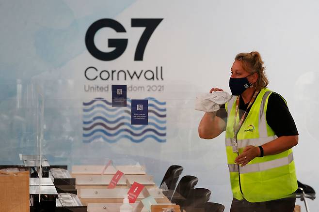 11일부터 3일간 열리는 G7 정상 회담을 앞두고 영국 콘월의  G7 미디어 센터에서 한 자원봉사자가 코로나 방역을 위한 칸막이를 점검 하고 있다./AFP 연합뉴스