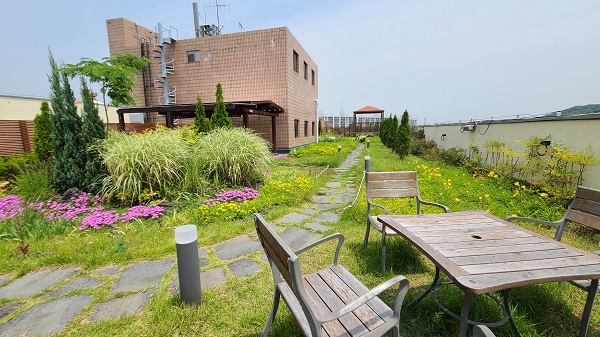 옥상 공원은 꽃과 초록의 풀로 미적으로도 아름다운 휴식 공간을 제공한다.
