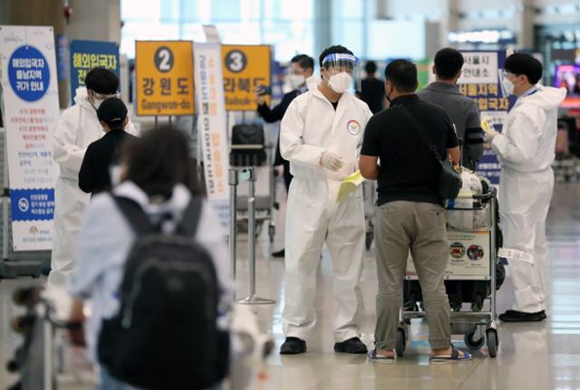 5월 20일 인천국제공항 1터미널 입국장에서 관계자들이 입국자들에게 방역 조치를 설명하고 있다. 뉴시스