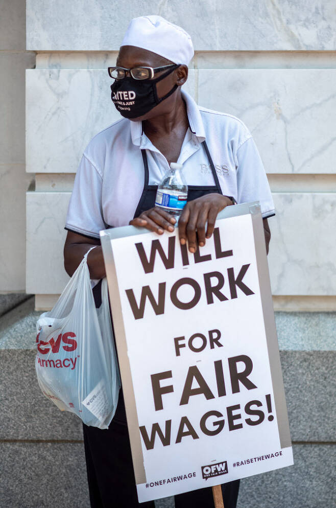 지난 26일 미국 워싱턴DC에서 시위자가 최저임금 인상을 요구하고 있다(사진=AFP)
