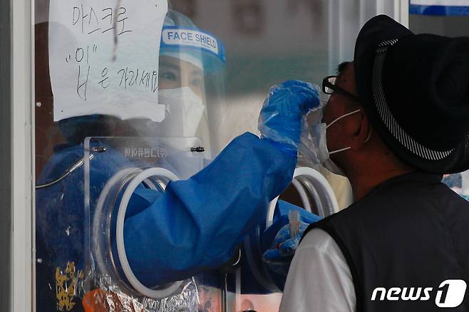 서울역에 마련된 중구임시선별진료소에서 의료진이 검체채취를 하고 있다. 뉴스1 자료사진. 2021.6.14/뉴스1 © News1 안은나 기자