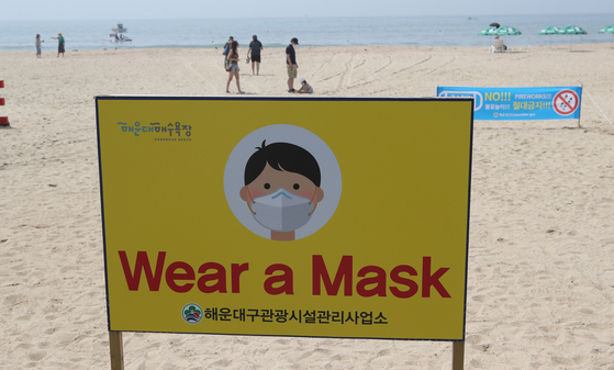 After a group of foreigners enjoyed fireworks at Haeundae beach without wearing face masks last year, an English sign was set up requesting people to wear masks. [SONG BONG-GEUN]
