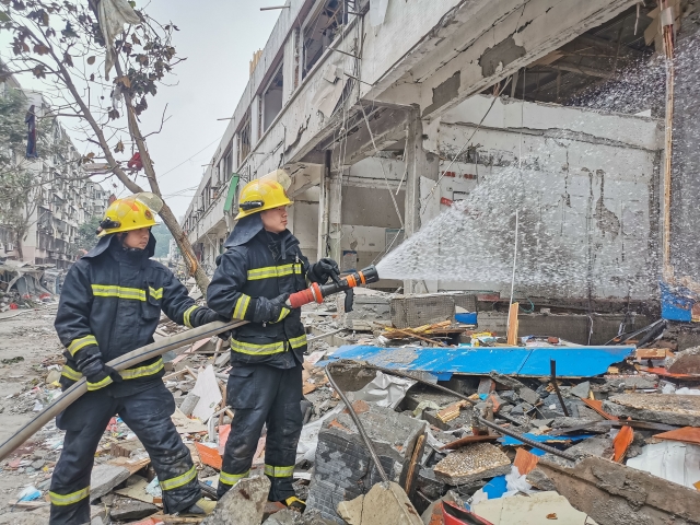 가스 폭발 사고가 발생한 중국 후베이성 스옌시의 식료품 시장에서 출동한 구조대원들이 현장을 수습하고 있다. 바닥에는 건물 잔해가 쌓여있다. 신화통신연합뉴스