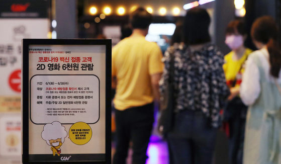 Moviegoers in Seoul on Sunday. Theater chains, including CGV and Lotte Cinema, offer around 50 percent discounts on movie tickets to people who have received at least one dose of the vaccine. [NEWS1]