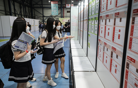 High school students review a job board at Setech in Gangnam, Seoul, Tuesday. The job market has been improving, with employment gains above 600,000 on year for two consecutive months, as the economy is rebounding from Covid-19. [YONHAP]