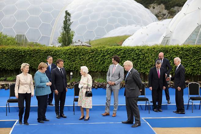 지난 11일(현지시간) 영국 콘월에서 열린 주요 7개국(G7) 정상회의에서 각국 정상들이 엘리자베스 2세 영국 여왕을 만나 기념사진을 찍고 대화를 나누고 있다. 스가 요시히데(菅義偉·왼쪽 세 번째) 일본 총리가 뒷줄에 홀로 서 있는 모습. [로이터]