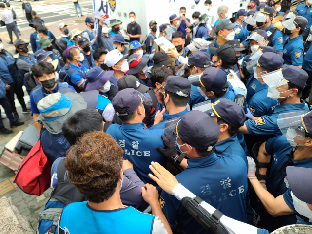 15일 서울 영등포구 여의도공원 입구 인근에서 경찰과 노조 측이 집회 장비 반입을 두고 몸싸움을 벌이고 있다./허진 기자