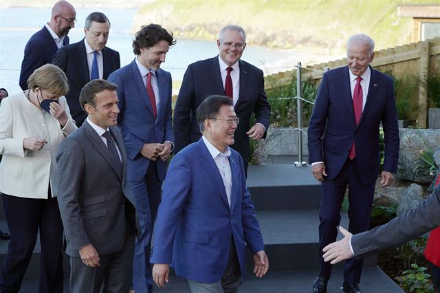 G7 정상들과 함께 이동하는 문대통령 - G7 정상회의 참석차 영국을 방문중인 문재인 대통령이 12일(현지시간) 영국 콘월 카비스베이 양자회담장 앞에서 참가국 정상들과 기념촬영 후 이동하고 있다.청와대 제공 2021.6.13