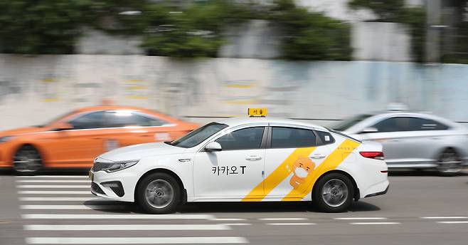 2021년 6월 13일 오후 서울역 앞 도로에서 카카오 래핑을 한 택시들이 줄 서 있는 택시들 앞을 지나가고 있다. 카카오 콜을 받지 않는 택시들은 승객을 기다리기 위해 길게 줄을 섰지만, 카카오 택시 중에는 줄 서서 대기하는 차량이 없었다. / 오종찬 기자