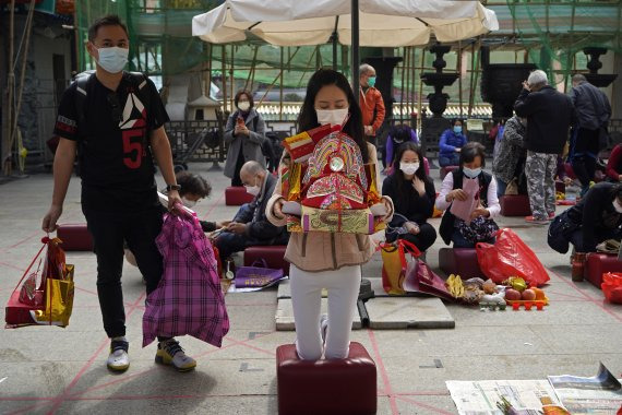 코로나19 확산 방지를 위해 마스크를 쓴 사람들이 18일 홍콩의 웡타이신 사찰에서 기도하고 있다.AP뉴시스