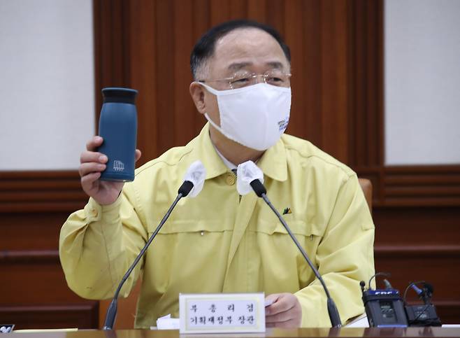 <YONHAP PHOTO-3535> 텀블러 사용 권유하는 홍남기 부총리       (서울=연합뉴스) 김승두 기자 = 홍남기 경제부총리 겸 기획재정부 장관이 18일 정부서울청사에서 열린 제38차 비상경제 중앙대책본부 회의 겸 2021년 제4차 혁신성장전략회의에 참석해 장관들에게 텀블러를 나누어주고 사용을 권유하고 있다. 2021.6.18      srbaek@yna.co.kr/2021-06-18 10:40:13/ <저작권자 ⓒ 1980-2021 ㈜연합뉴스. 무단 전재 재배포 금지.>