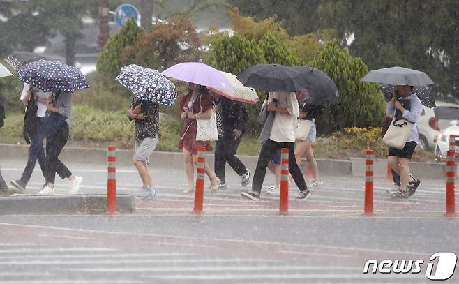 대전 유성구 충남대학교 앞 횡단보도에서 시민들이 비를 피하기 위해 발걸음을 재촉하고 있다. 뉴스1 © News1