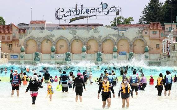 경기도 용인 캐리비안베이를 찾은 시민들이 마스크를 쓴 채 야외 파도풀에서 물놀이를 하고 있다. 캐리비안베이는 코로나19 예방을 위해 방문일이 지정된 입장권을 사전에 구입하거나 홈페이지에서 방문일을 예약하는 ‘사전 예약제’를 실시하고 있다. 사진=박범준 기자