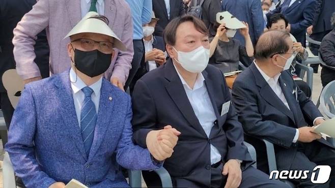 홍경표 윤사모 중앙회장(왼쪽)과 윤석열 전 검찰총장이 지난 9일 서울 남산예장공원에서 열린 우당 기념관 개관식에 참석해 손을 맞잡고 있다. (윤사모 제공) ©뉴스1